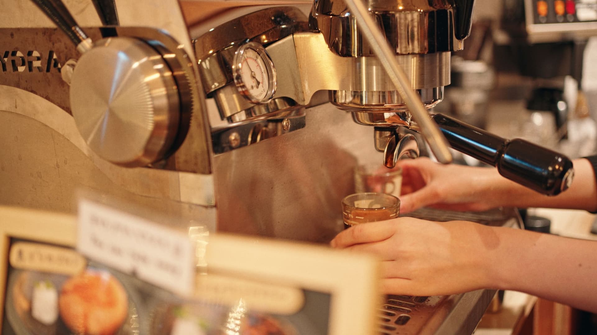 An Aroma barista at the espresso machine