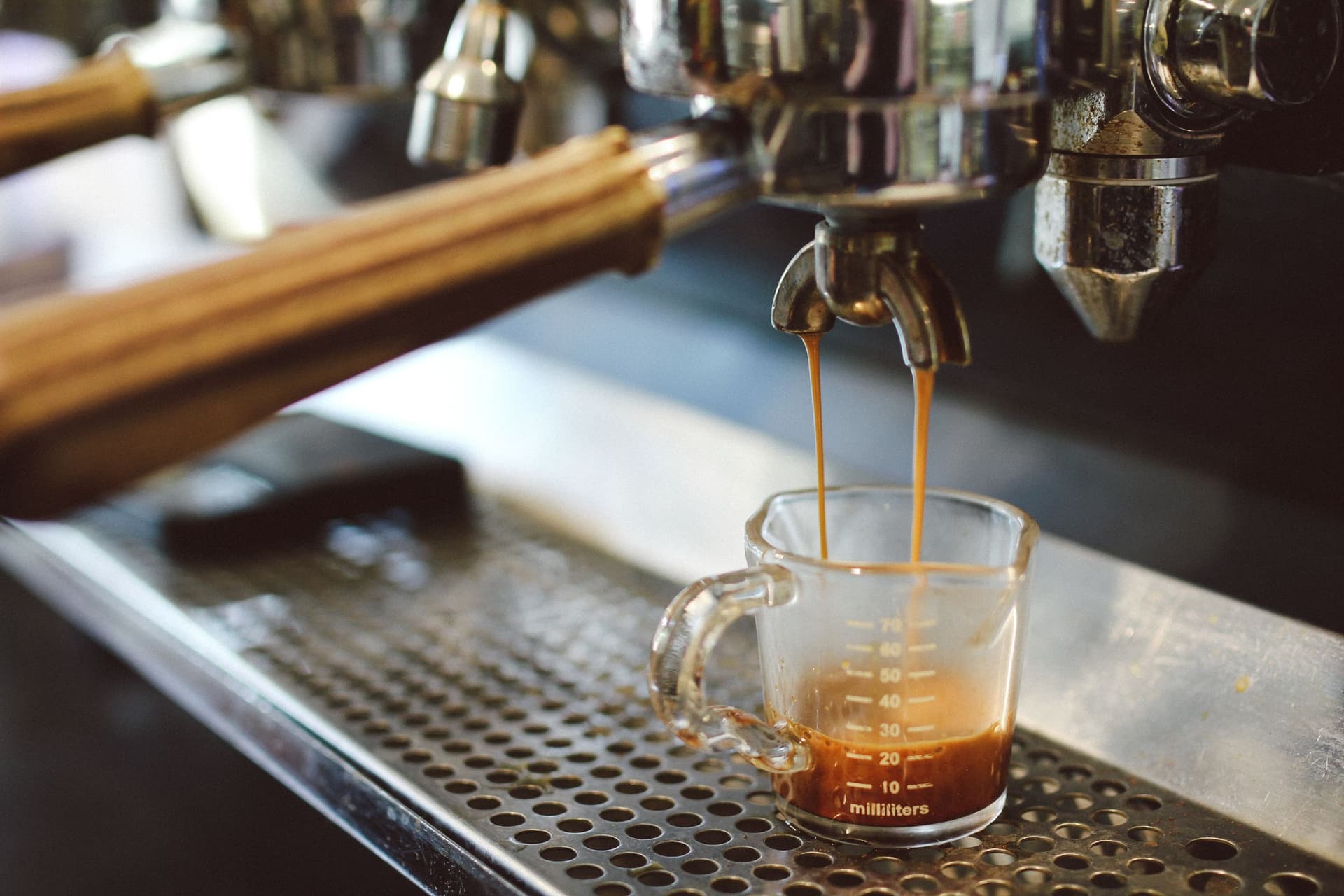 A cinematic espresso pull at an Aroma Baristas event bar
